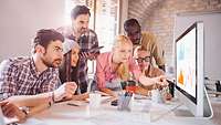 Gruppe von jungen Männern und Frauen beim Planspiel am Laptop